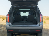 2021-chevrolet-tahoe-z71-middle-east-exterior-021-rear-end-dirt-road-liftgate-open-third-row-folded