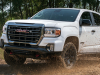 2021-gmc-canyon-at4-off-road-performance-edition-exterior-017-front-end-off-road-kicking-up-dirt