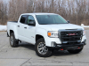 2021-gmc-canyon-at4-summit-white-crew-cab-short-bed-gma-garage-exterior-002-front-three-quarters-pavement