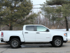 2021-gmc-canyon-at4-summit-white-crew-cab-short-bed-gma-garage-exterior-003-side-profile-pavement