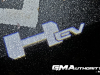 2022-gmc-hummer-ev-pickup-edition-1-gma-garage-exterior-at-night-003-hummer-ev-logo-projected-on-ground