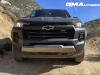 2023-chevrolet-colorado-trail-boss-harvest-bronze-metallic-gxn-offroad-first-drive-exterior-009-front-black-chevy-logo-grille-black-tow-recovery-hooks_0