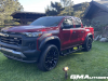 2023-chevrolet-colorado-trail-boss-radiant-red-tintcoat-gnt-first-drive-exterior-001-side-front-three-quarters-accessory-wheels-steps