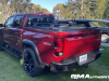 2023-chevrolet-colorado-trail-boss-radiant-red-tintcoat-gnt-first-drive-exterior-009-rear-three-quarters-tonneau-cover-removable-rail-kit-by-thule-surf-board