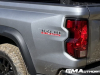 2023-chevrolet-colorado-trail-boss-sterling-gray-metallic-gxd-offroad-first-drive-exterior-002-trail-boss-logo-on-bedside-tail-light-dirty-rear-goodyear-wrangler-territory-at-tire_0