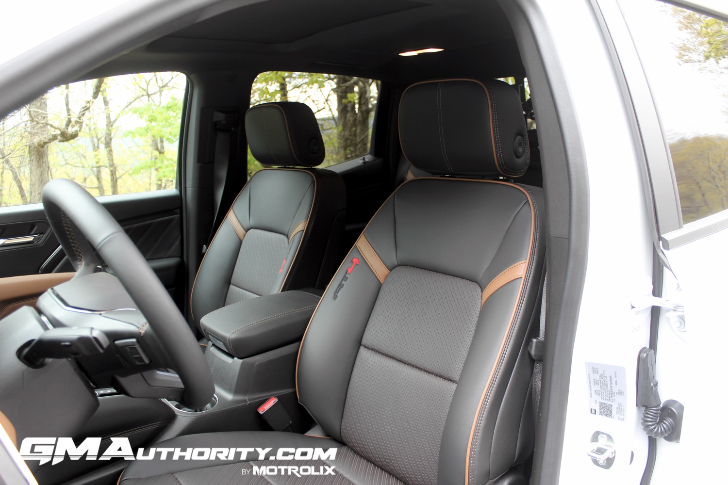 2023-gmc-canyon-at4-jet-black-with-timber-hx6-first-drive-interior-007-front-seats-center-console-armrest