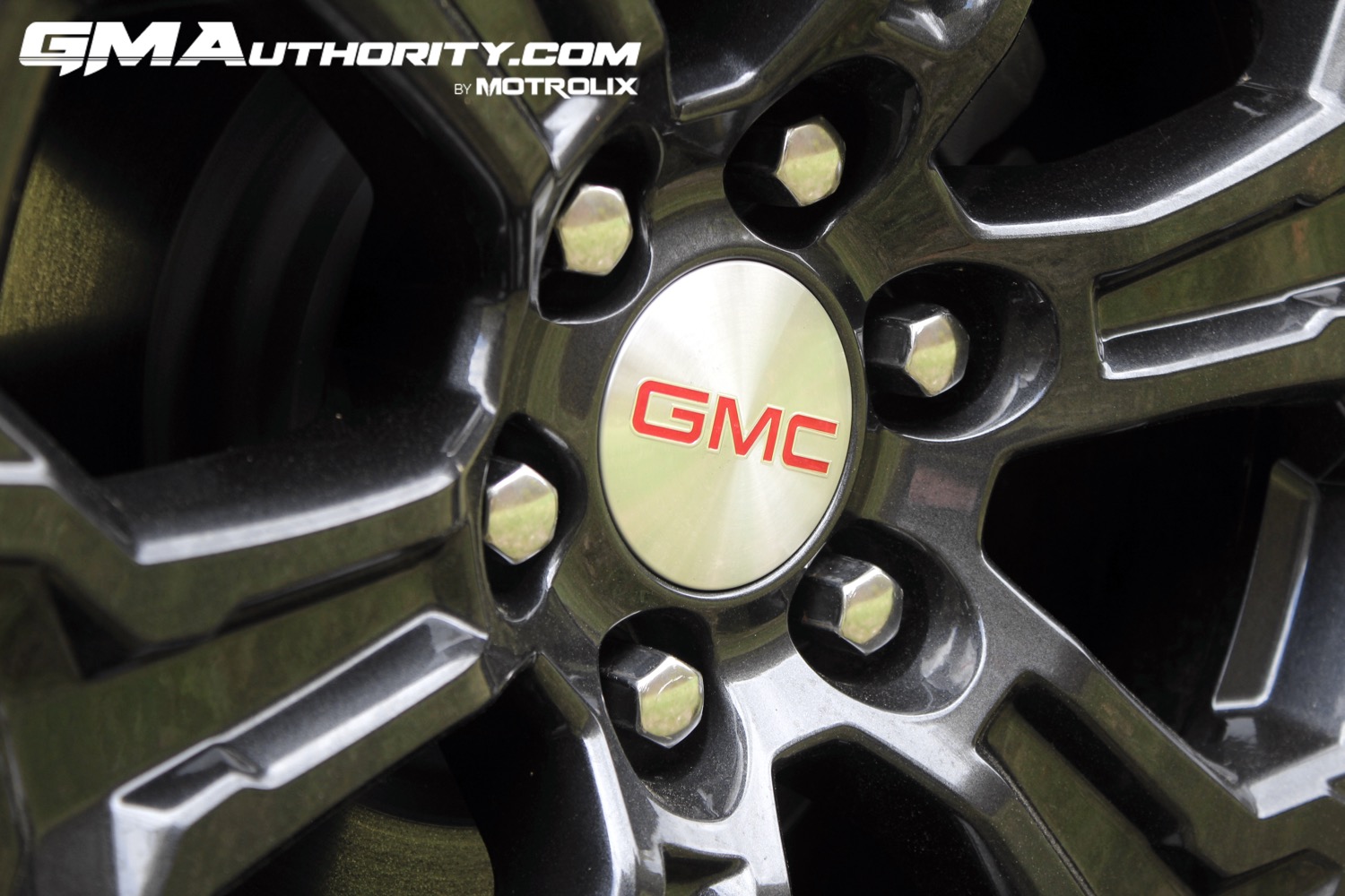 2023-gmc-canyon-elevation-sterling-metallic-gxd-first-drive-exterior-021-18-inch-gloss-black-wheel-gmc-logo-on-center-cap