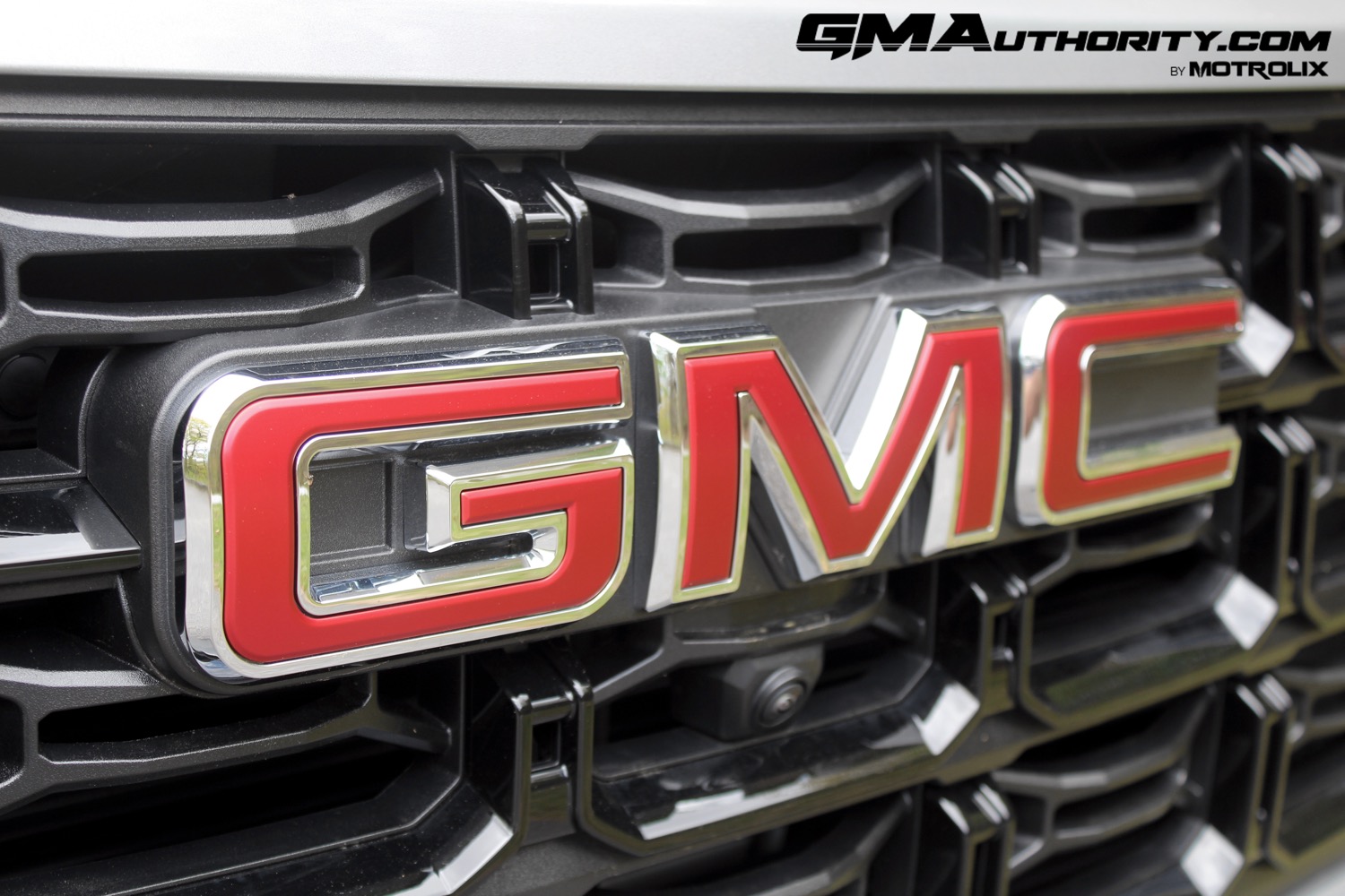 2023-gmc-canyon-elevation-sterling-metallic-gxd-first-drive-exterior-032-gmc-logo-badge-on-grille-front-camera