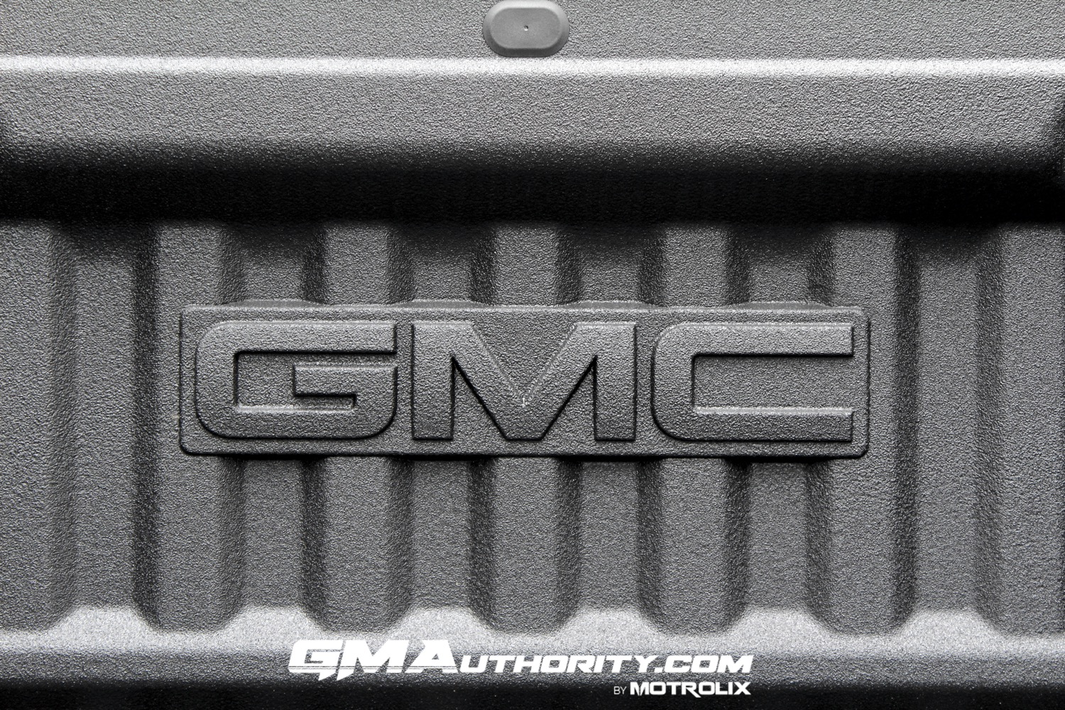 2023-gmc-canyon-elevation-sterling-metallic-gxd-first-drive-exterior-087-bed-gmc-logo-on-bulkhead