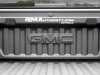 2023-gmc-canyon-elevation-sterling-metallic-gxd-first-drive-exterior-086-bed-gmc-logo-on-bulkhead