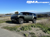 2024-gmc-hummer-ev-suv-3x-edition-1-moonshot-green-matte-g7w-first-drive-exterior-037-side-front-three-quarters-spare-tire-extract-mode