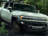 2024-gmc-hummer-ev-suv-exterior-033-front-three-quarters-driving-through-mud-roof-panels-off