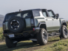 2024-gmc-hummer-ev-suv-extreme-off-road-package-z6x-moonshot-green-matte-g7w-press-photos-exterior-028-rear-three-quarters-infinity-roof-panels-removed