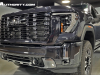 2024-gmc-sierra-2500-hd-denali-ultimate-titanium-rush-metallic-g6m-reveal-photos-exterior-012-front-three-quarters-vader-chrome-gmc-logo-badge-and-grille-headlight-tow-recovery-hook