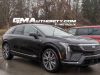 2025-cadillac-optiq-black-real-world-photos-march-2024-exterior-002-side-front-three-quarters