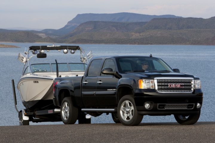 Front three quarters view of the 2011 GMC Sierra towing a boat. 