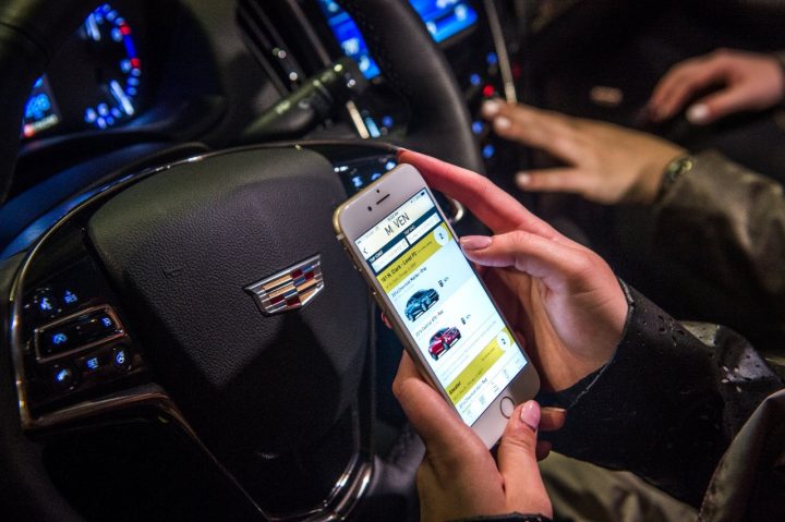 A GM customer looks at the Maven app on their smartphone.