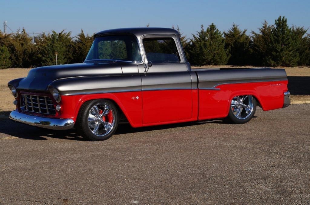 This professionally-built 1955 Chevrolet Cameo Custom Pickup features several eye-catching outer modifications including a tailgate inspired by the 1955 Nomad, reformed cab corners to flow with the 1957 Bel Air side trim and an engine bay that is smoothed over with covers. The Titanium Grey and Lipstick Red exterior is complemented by a red leather interior, complete with Dakota Digital VHX gauges, a graphite-wrapped Billet Specialties wheel and a Kenwood stereo system.