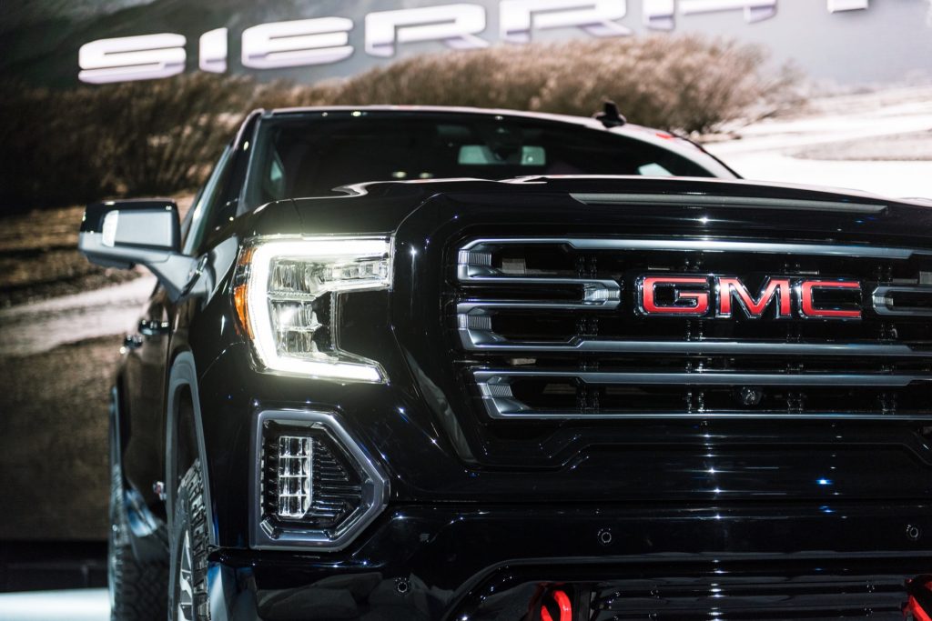 2019 GMC Sierra AT4 1500 exterior live at 2018 New York Auto Show 021 front end spotlight with headlight and grille and GMC logo