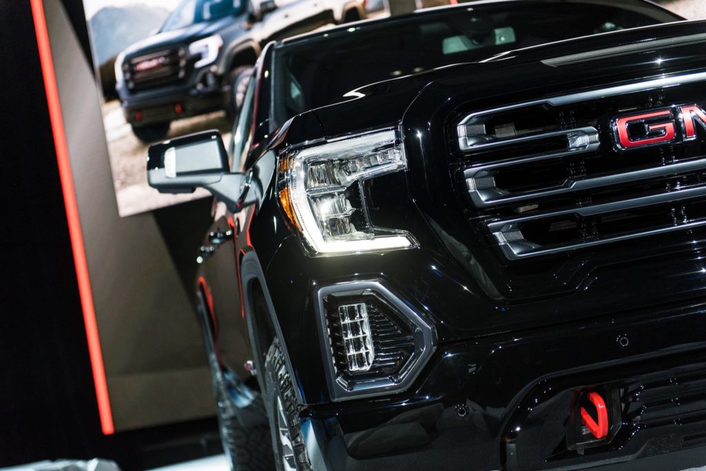 2019 GMC Sierra AT4 1500 exterior live at 2018 New York Auto Show 022 front end spotlight with headlight and grille and GMC logo