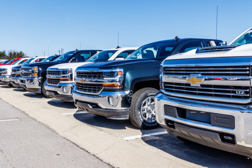 Chevy Silverado trucks lined up on a dealership lot.