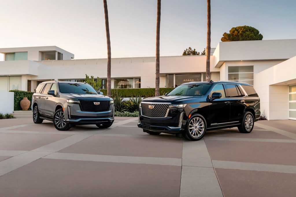 The front ends of two Cadillac Escalade SUVs.