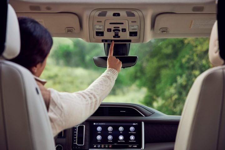 Pressing the OnStar button in a GMC SUV.