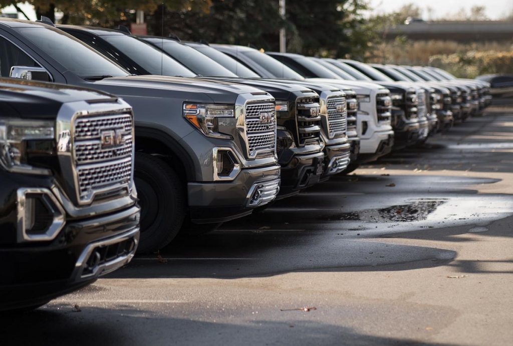 A lineup of GMC Sierra trucks at a GM dealership.