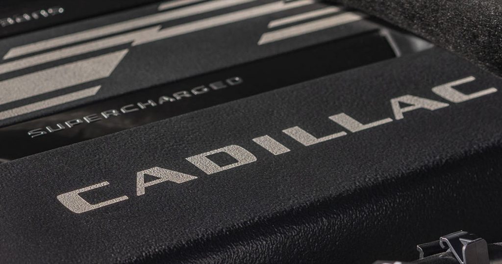 The Cadillac script logo on a supercharger cover.