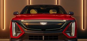 2024 Cadillac Lyriq - Sport - 600E4 - Radiant Red Tintcoat GNT - Press Photos - Exterior 003 - front - Cadillac logo badge on illuminated grille - DRL daytime running lights - headlights
