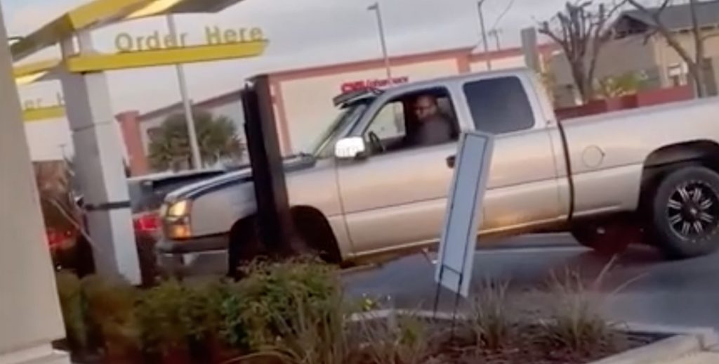 A Chevy Silverado attempts to back out of a fast food drive-thru line.