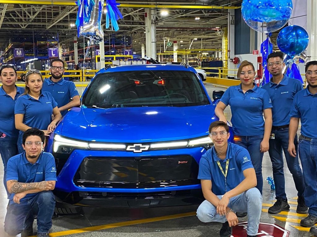 Photo of production workers posing next to a 2024 Chevy Blazer EV RS.