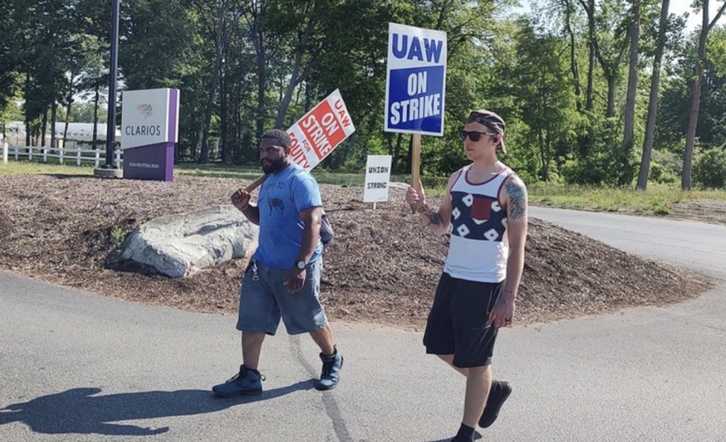 Photo of UAW workers waving signs.