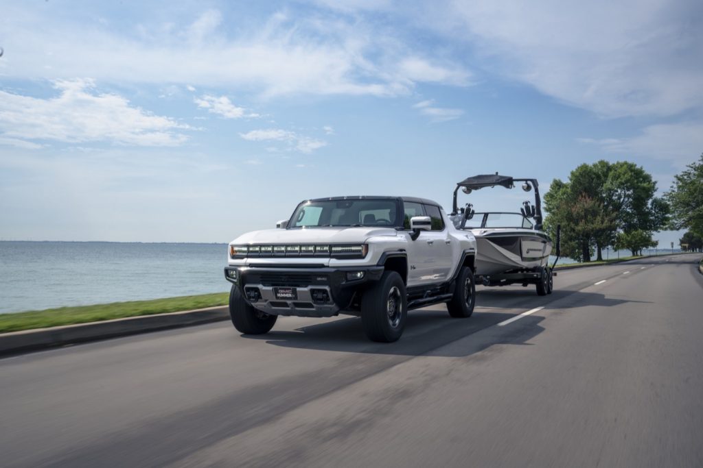 The front end of the GMC Hummer EV as it tows a boat.