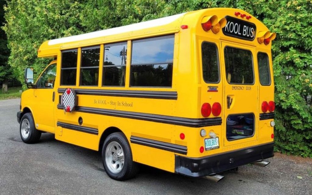Modified Chevy Express school bus with a massive supercharger.
