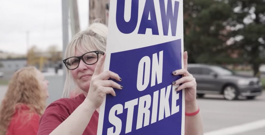 A UAW worker holding a strike sign. 