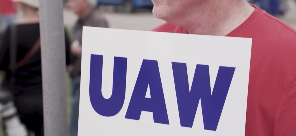 A worker holding a UAW sign. 