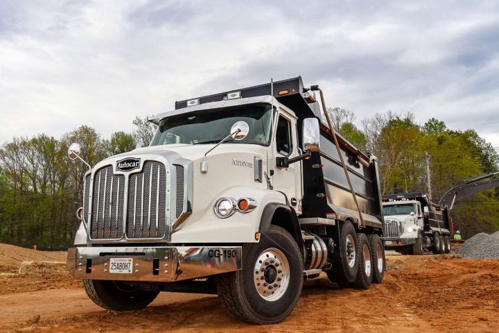Front three quarters view of an Autocar and GM dump truck.