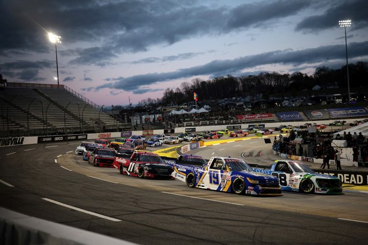 A row of race trucks on the Martinsville Speedway, including NASCAR Chevy Silverado RST trucks.