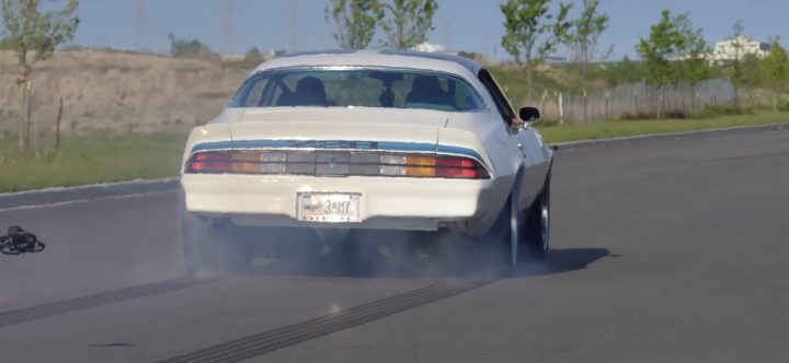 The rear end of a custom 1979 Chevy Camaro burning rubber.