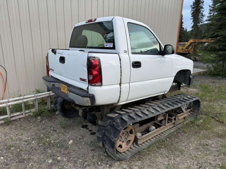 Heavily modified GMC Sierra on a set of tank treads.