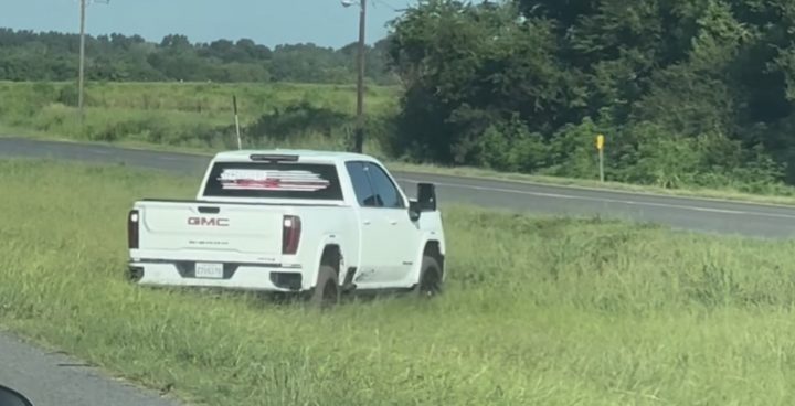 A GMC Sierra HD off-roading in a ditch.