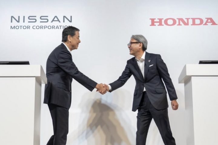 Nissan and Honda executives shaking hands.