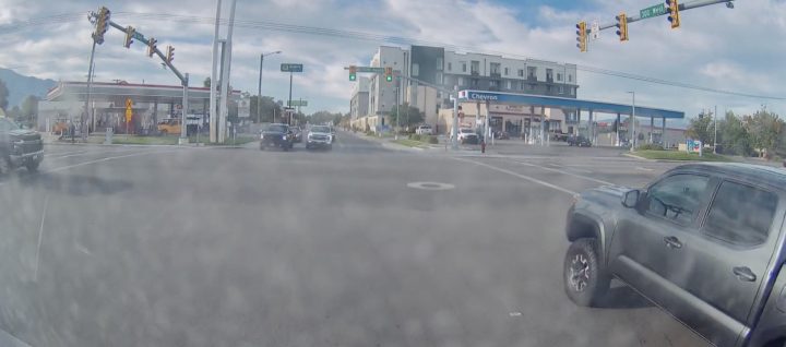 A Chevy Silverado HD approaches an intersection at high speed, moments before colliding with a Toyota Tacoma.