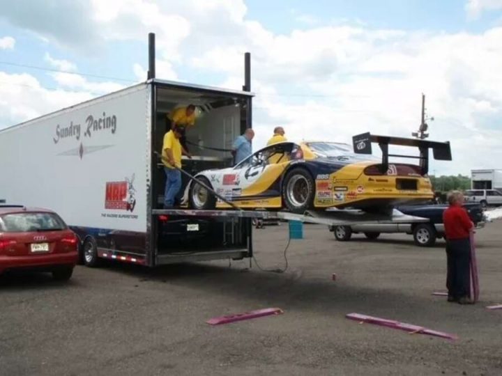 Rear three quarters view of the transport truck and the Oldsmobile Aurora.