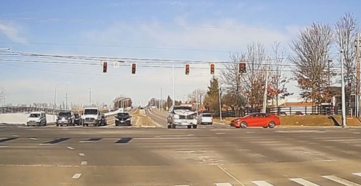 Cadillac Escalade barrels through intersection before colliding with another vehicle.