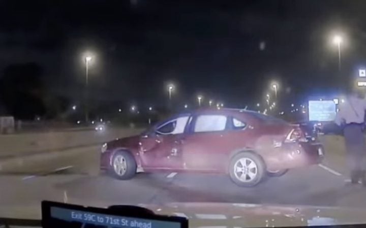 A crashed Chevy Impala stopped on a highway.