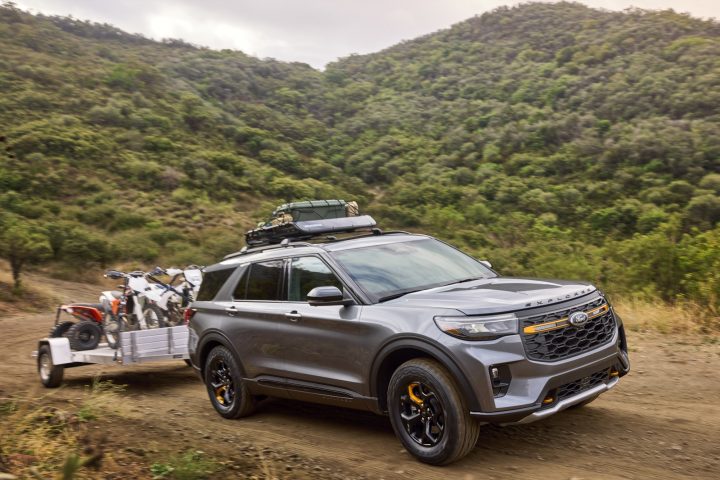 The 2026 Ford Explorer Tremor tows some dirt bikes on a trail.